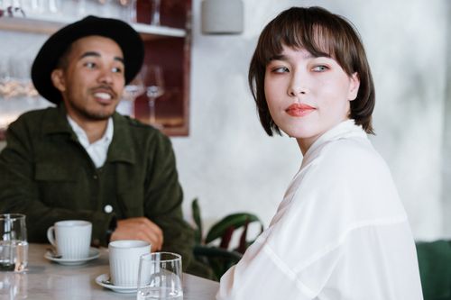 Free A stylish couple enjoys a conversation in a modern café setting, creating a relaxed atmosphere. Stock Photo