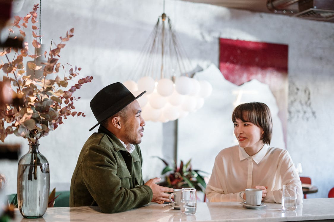 {{https://mixerdates.com/?ch=mixerblog}}A candid moment capturing a friendly chat in a stylish café setting. Elegant and warm
