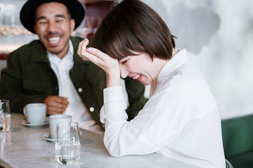 Wanita Berbaju Putih Memegang Gelas Minum Bening