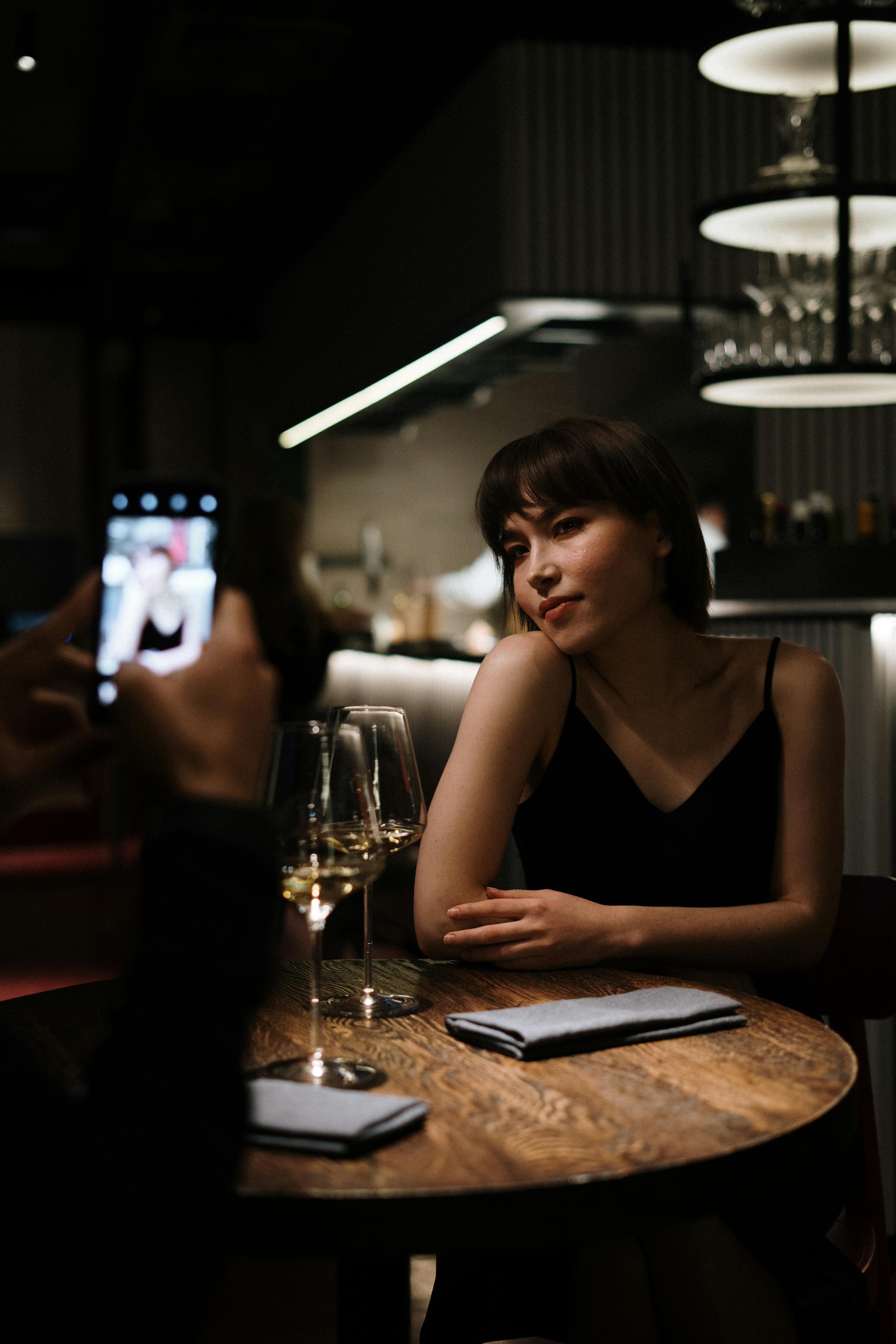 woman in black tank top holding smartphone