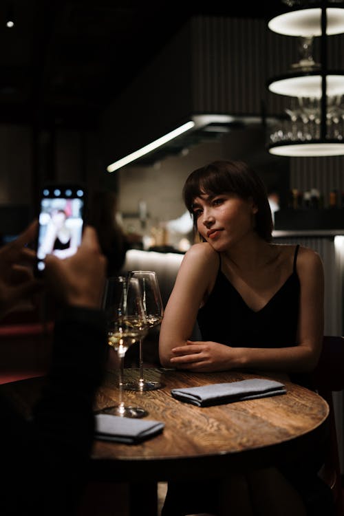 Free Woman in Black Tank Top Holding Smartphone Stock Photo