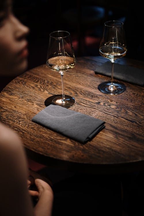 棕色木製的桌子上的透明酒杯