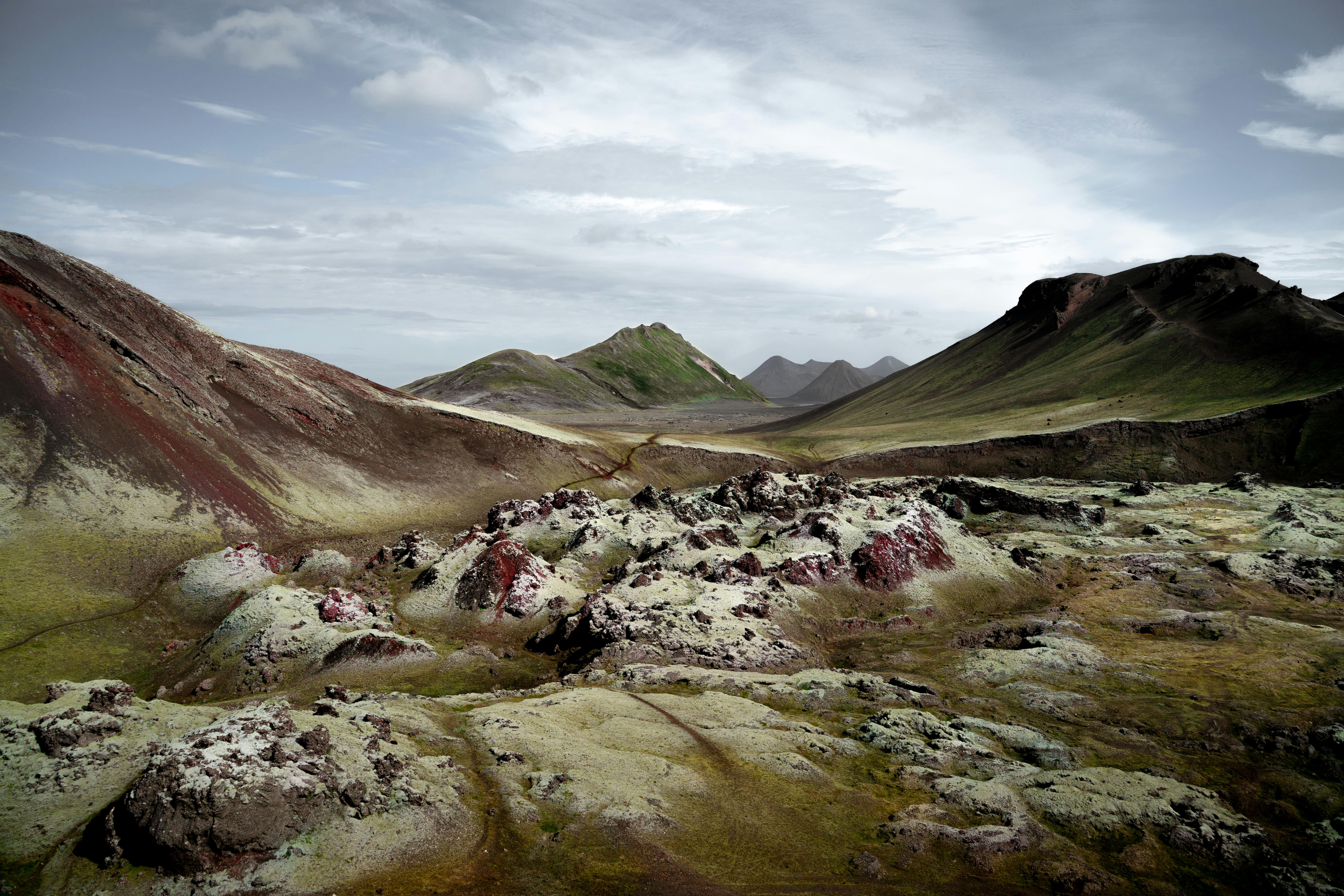 Mossy mountains with valley of boulders under cloudy sky · Free Stock Photo