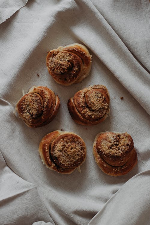 Yummy cinnamon buns on linen towel at home