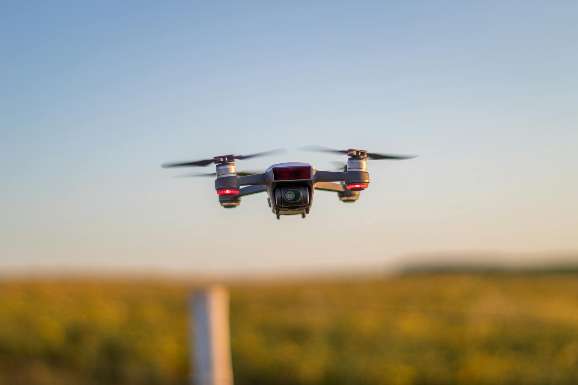 Drone in flight over a scenic rural field, capturing golden hour light.