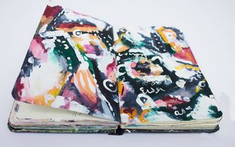 Open sketchbook with a colourful abstract painting inside — photo by Deeana Arts on Pexels
