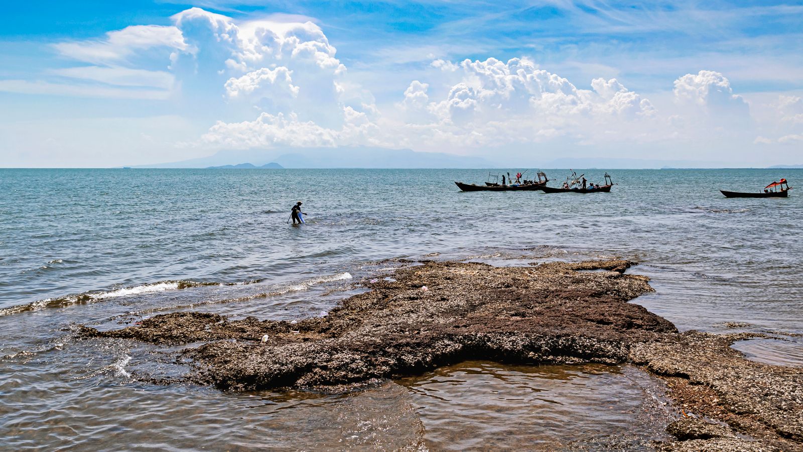 Fishing boats off the rocky shore near Kep, Cambodia — coastal-only itinerary