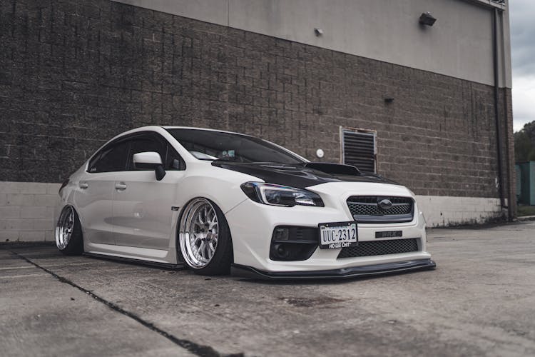 Black And White Car Parked On Asphalt Ground Near Building