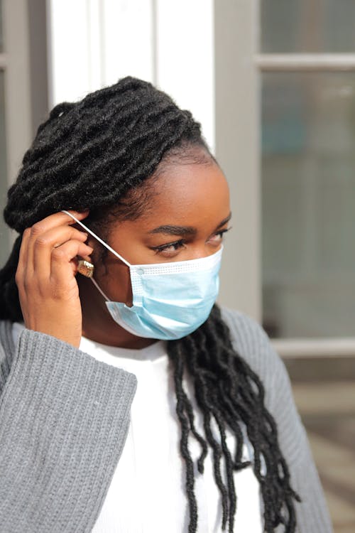 A Woman in a Cardigan Wearing a Face Mask 