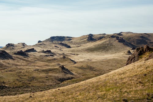 Picturesque view of mountainous valley located in barren area against blue sky