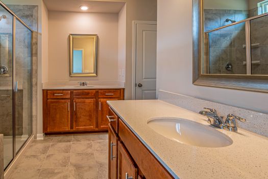 Stylish bathroom featuring wooden cabinets, a sink, and a glass shower enclosure.