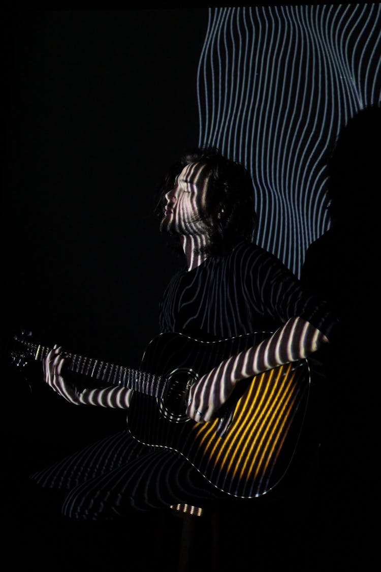 Guitarist Performing Music In Neon Lights In Club