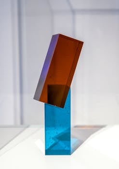 Minimalist glass sculpture with intersecting forms in a museum setting.