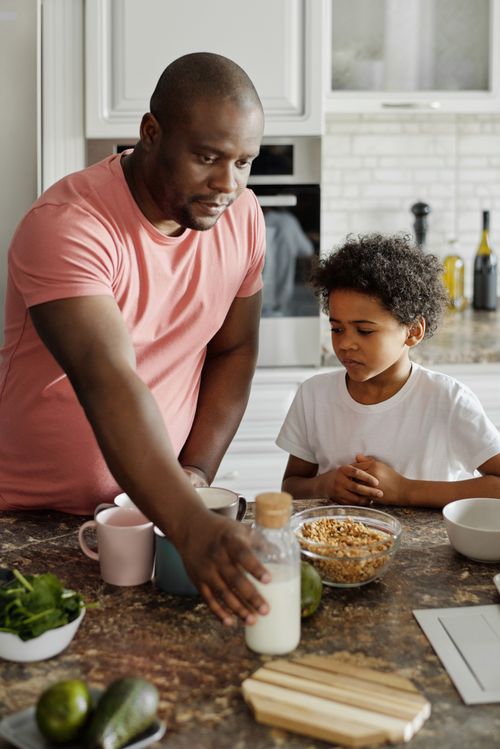 Free Father and son bonding during breakfast in a cozy kitchen setting. Stock Photo