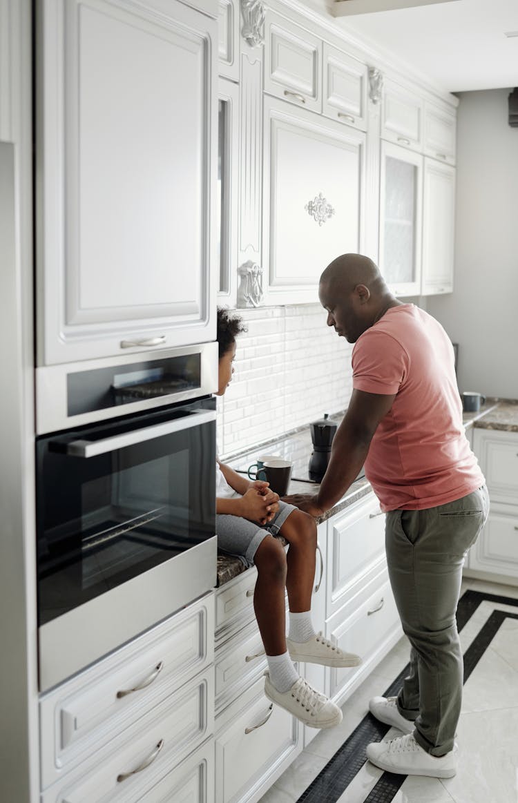 Father And Son Talking In The Kitchen