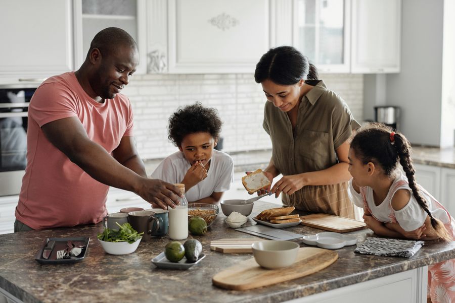 Famille française souriante devant sa maison à volets bleus