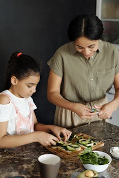 A mother and daughter cutting vegetables on a kitchen counter, fostering healthy eating habits.