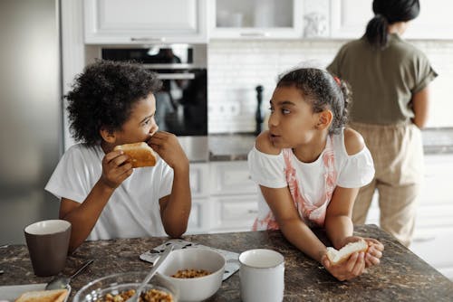 Free Brother and Sister in the Kitchen Eating Breakfast Stock Photo