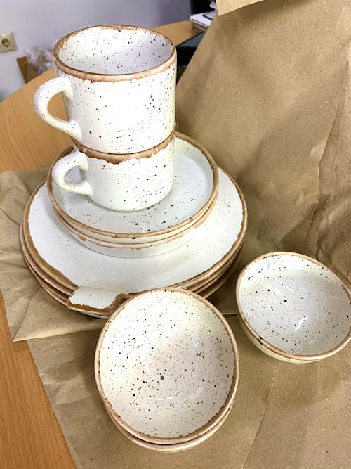 Set of white ceramic dishware on packing paper