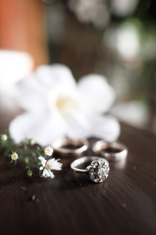 Selective Focus Photo of an Engagement Ring Near Flowers
