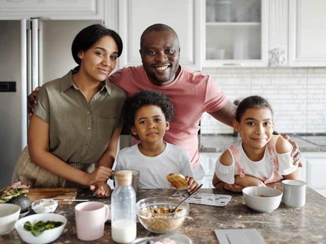 A family of four together in the kitchen of their home