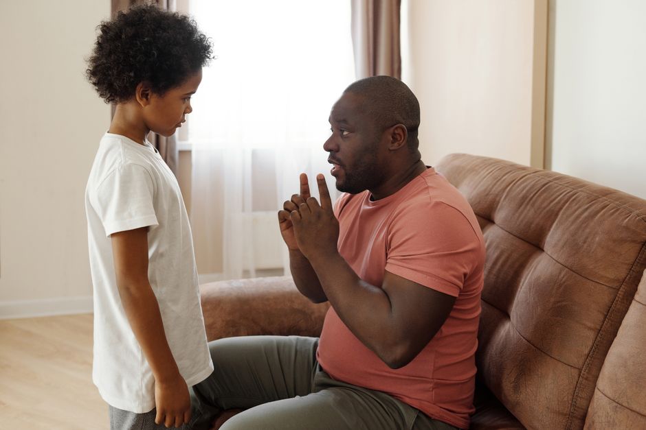 Father and son having an important talk at home, focusing on parenting and communication.
