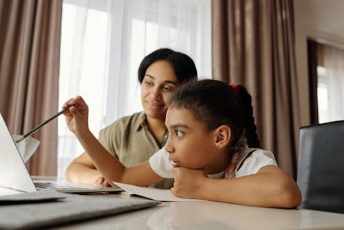 Мать помогает дочери с домашним заданием