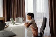 在一个阳光明媚的房间里，一个年轻的女孩正专注于她的家庭作业，象征着教育和专注