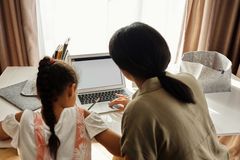 Mother helping her daughter with homework