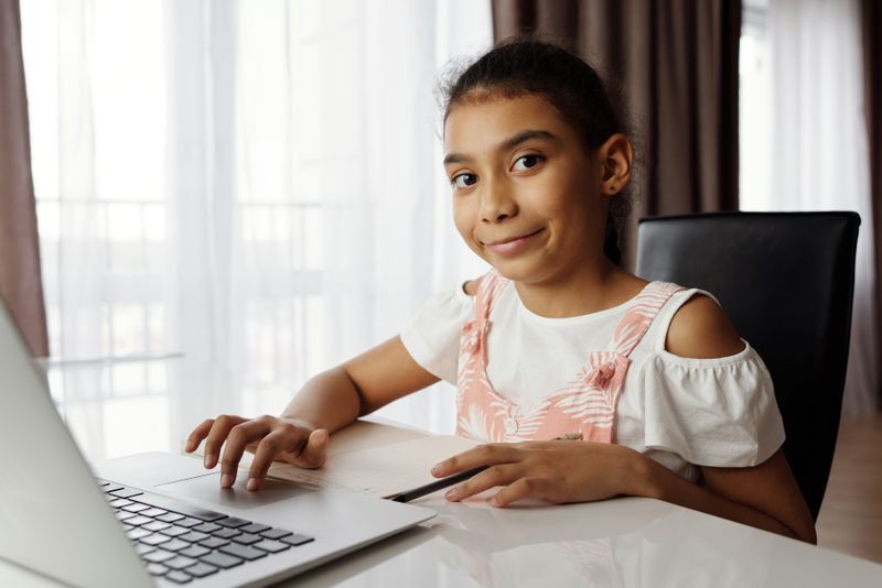 Niña feliz aprendiendo francés online desde casa