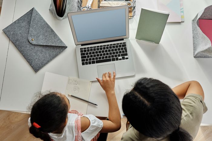 Mãe acompanhando filha nos estudos em casa