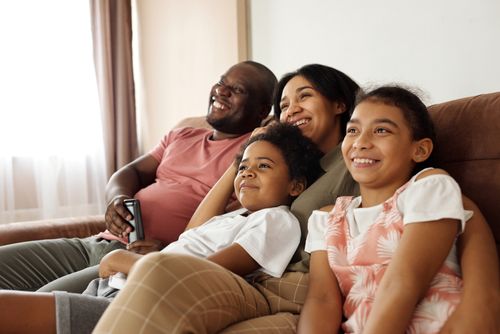 Free Happy multicultural family enjoying quality time together on a sofa at home. Stock Photo