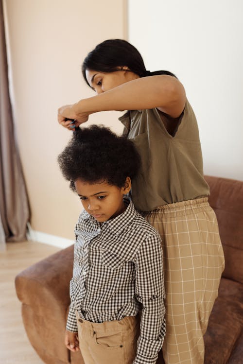 Free Mother Helping her Son to get Changed Stock Photo