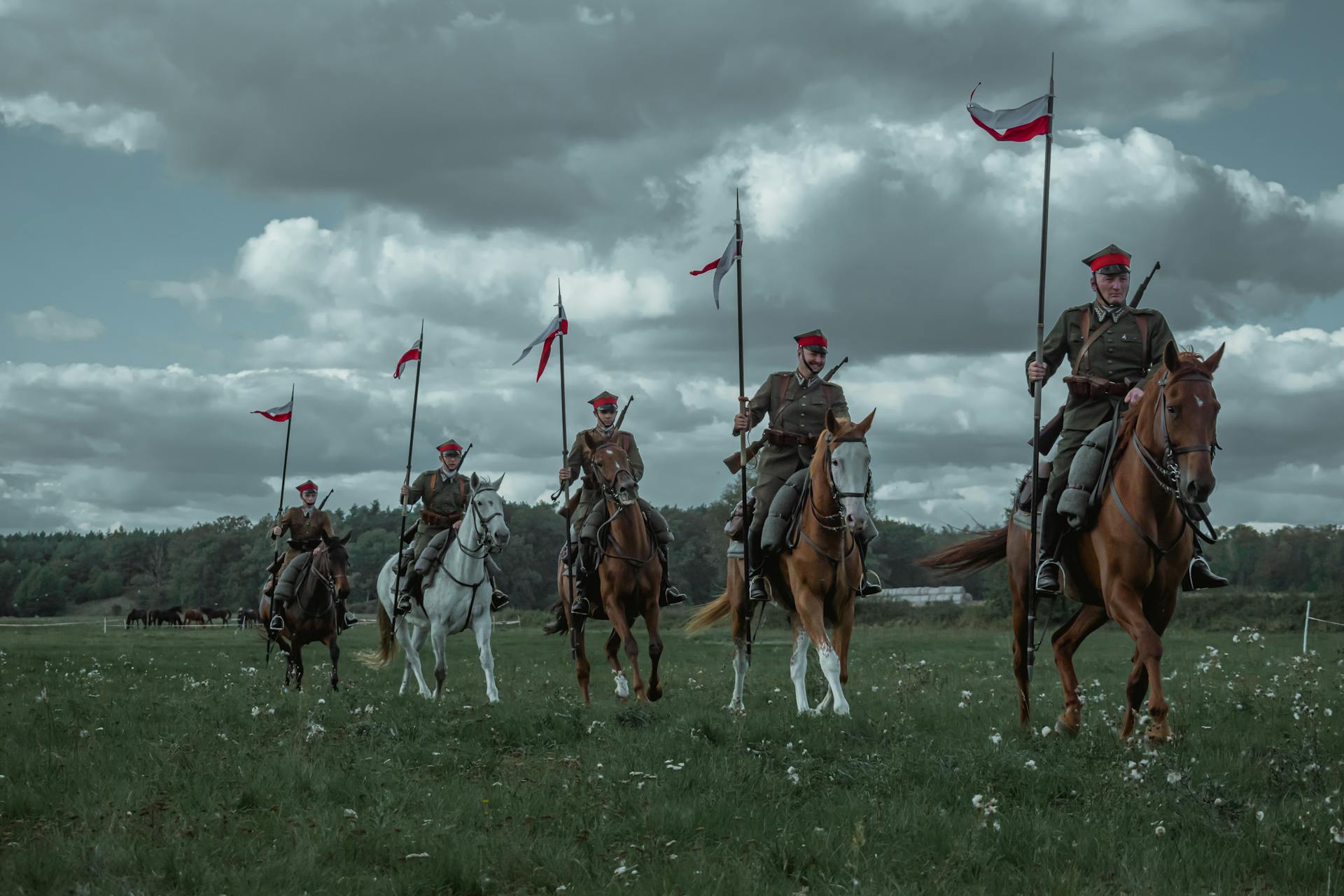 Män som rider på hästar med polska flaggor