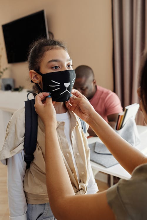 Ibu Mengenakan Masker Wajah Pada Putrinya