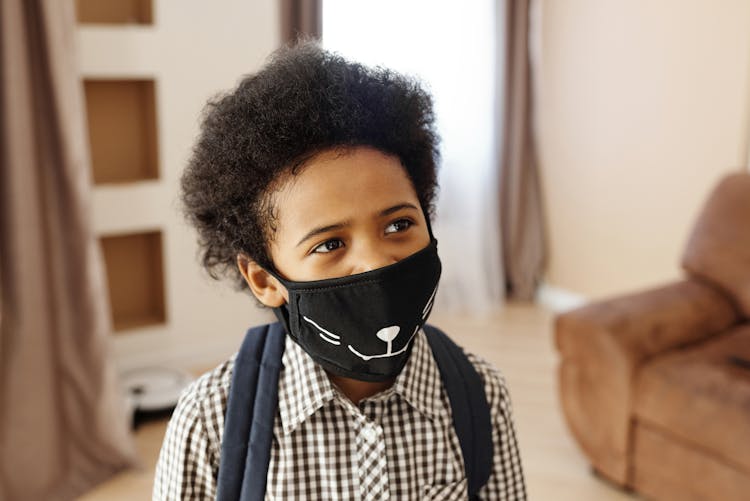 Little Boy Wearing A Face Mask With A Design