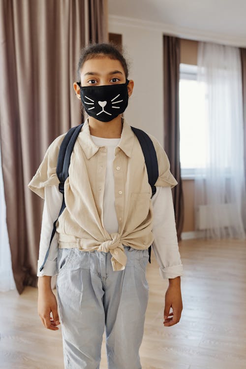 Free Little Girl Wearing a Face Mask With a Design Stock Photo