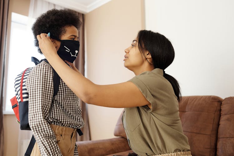 Mother Putting A Face Mask On Her Son