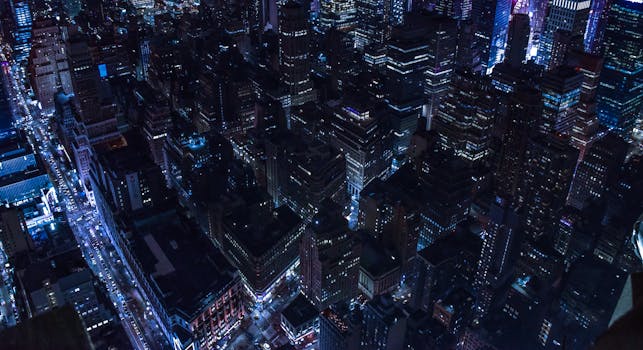 Stunning aerial shot of a glowing cityscape at night showcasing vibrant lights and bustling streets.