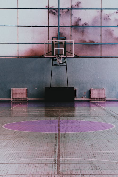 Free Small basketball hoop under big broad light pink window in bright spacious sports hall Stock Photo