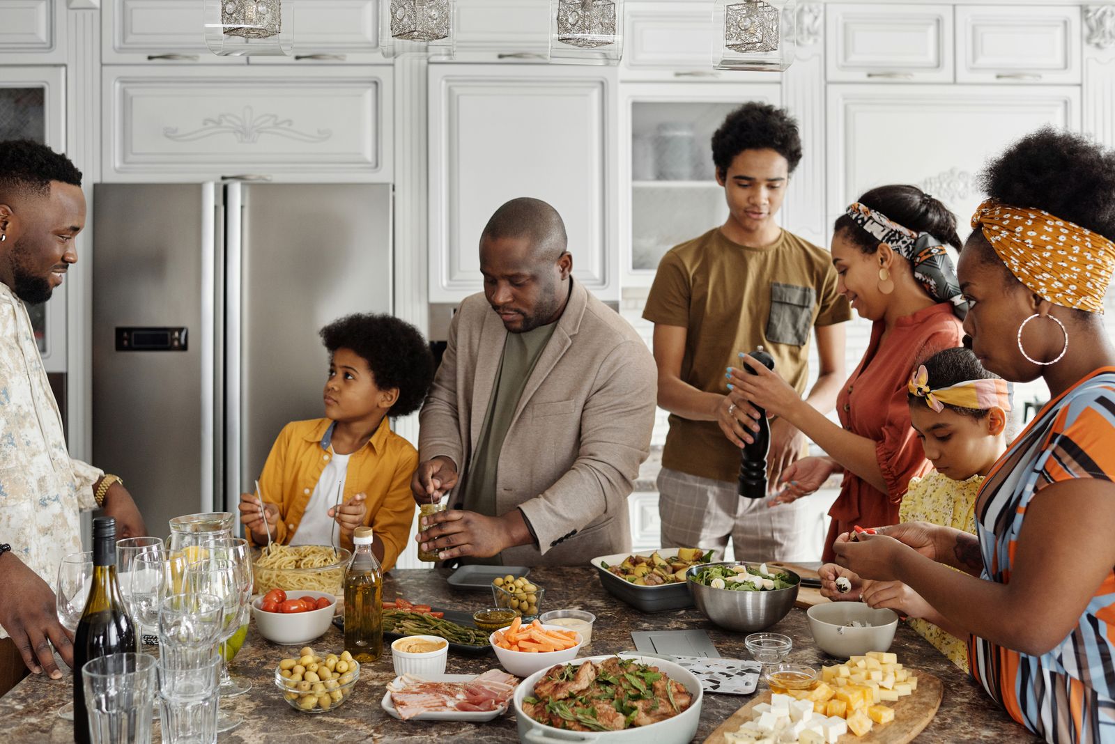 Family members preparing food together around a kitchen counter.