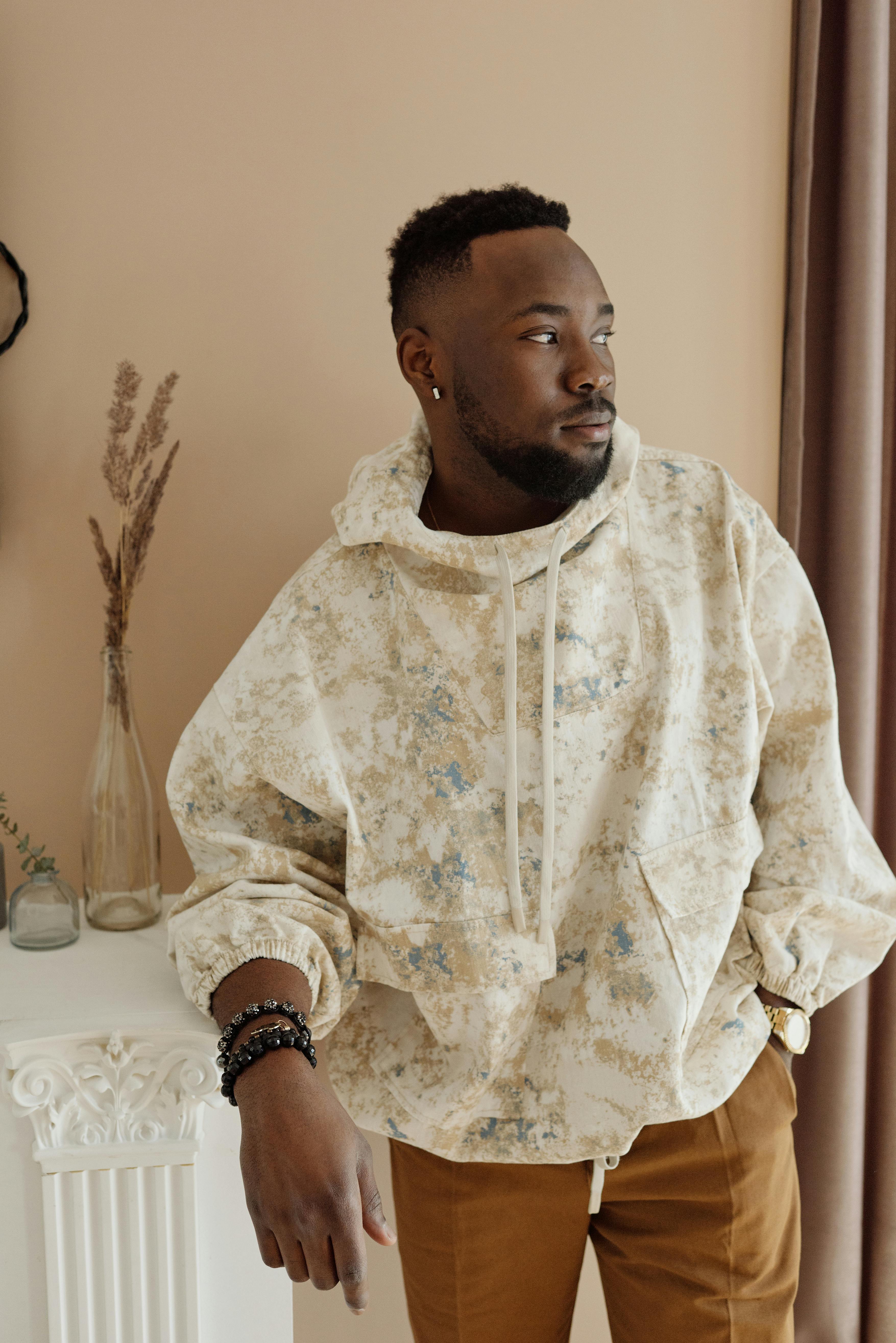 穿着图案连帽衫的年轻人在室内摆出姿势，散发出时尚又酷炫的氛围