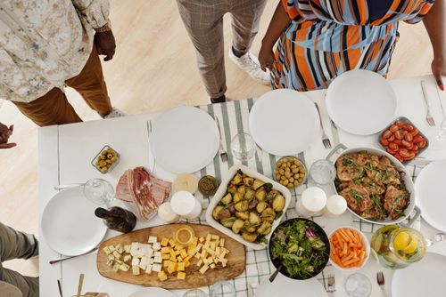 Free Top view of a diverse family enjoying a colorful dinner table with various delicious dishes. Stock Photo