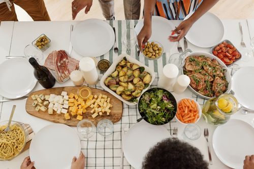 Free Overhead view of a family gathering with a variety of foods on a dining table. Stock Photo