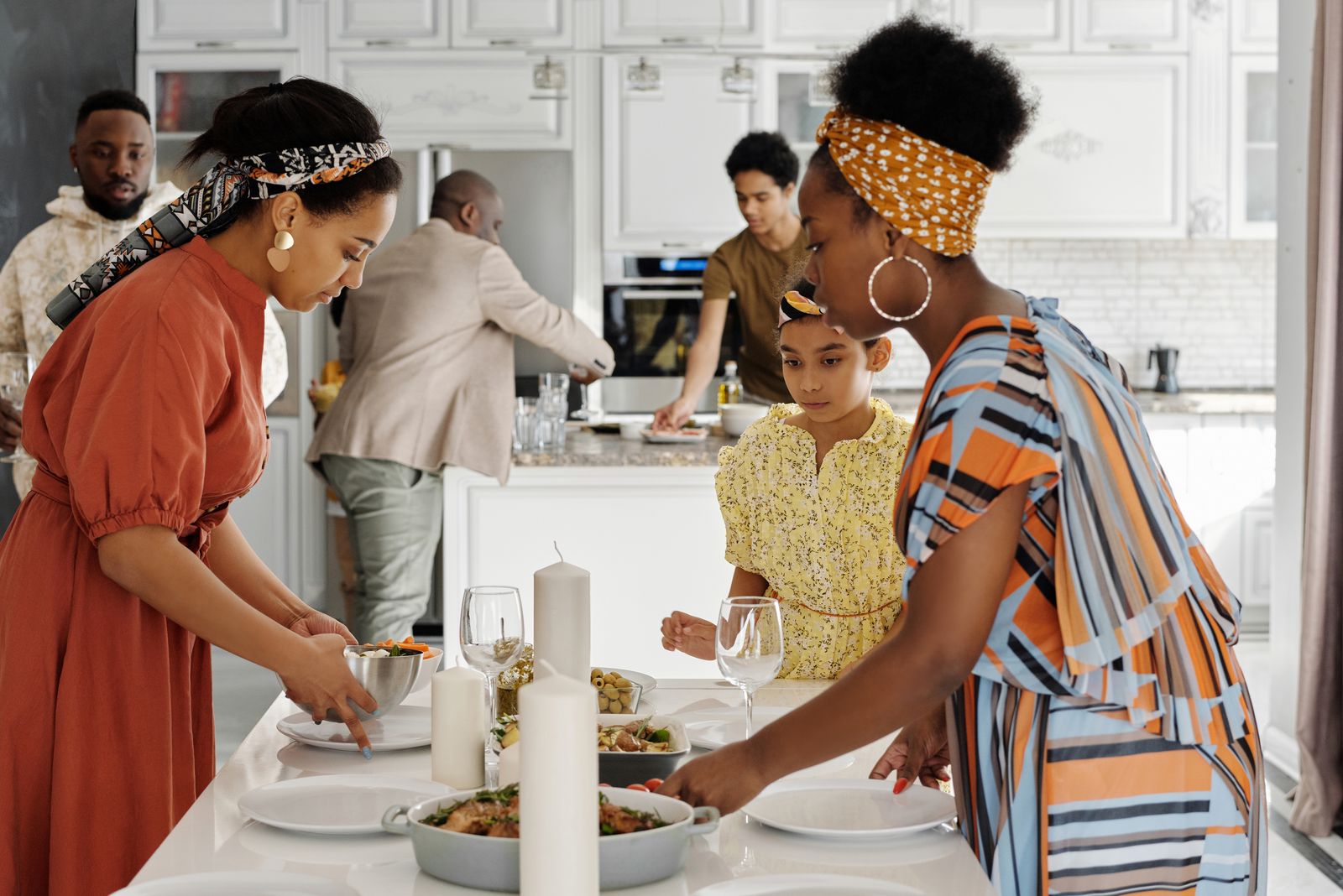 Family setting a table for dinner in a home kitchen