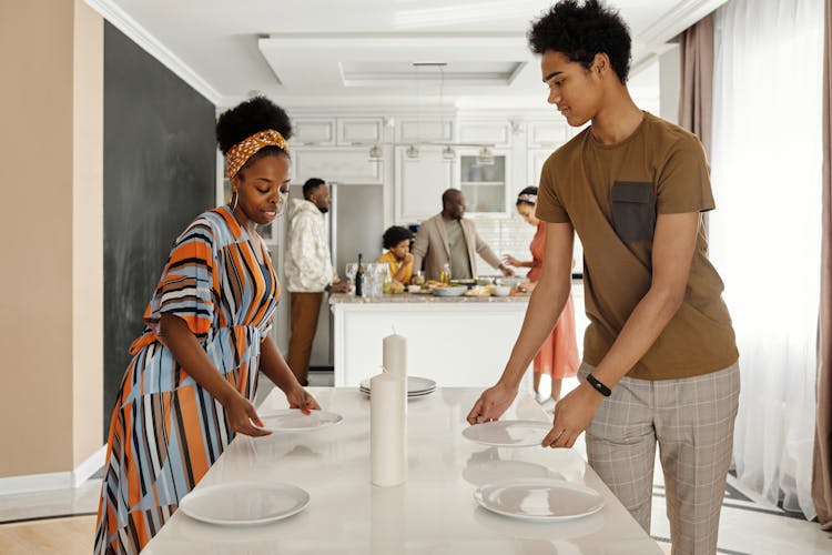 Family Setting The Table For Dinner