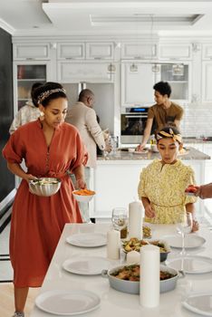 A family gathers in a modern kitchen to prepare and enjoy a meal together, focusing on togetherness and culture.