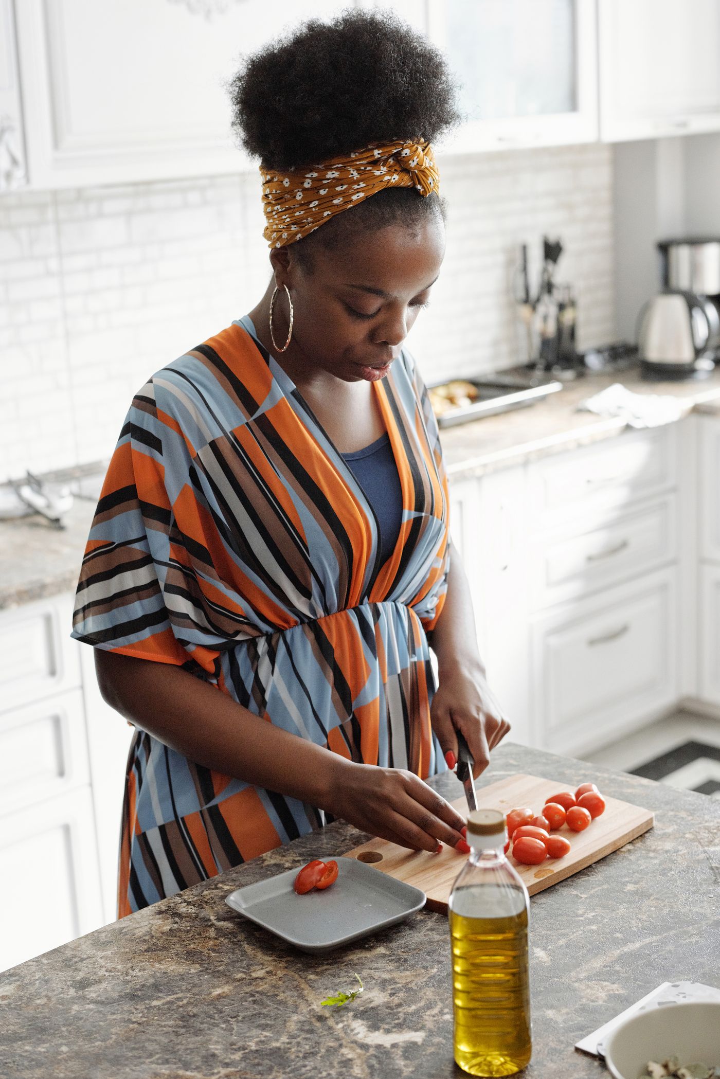 Une femme noire préparant des légumes dans une cuisine domestique