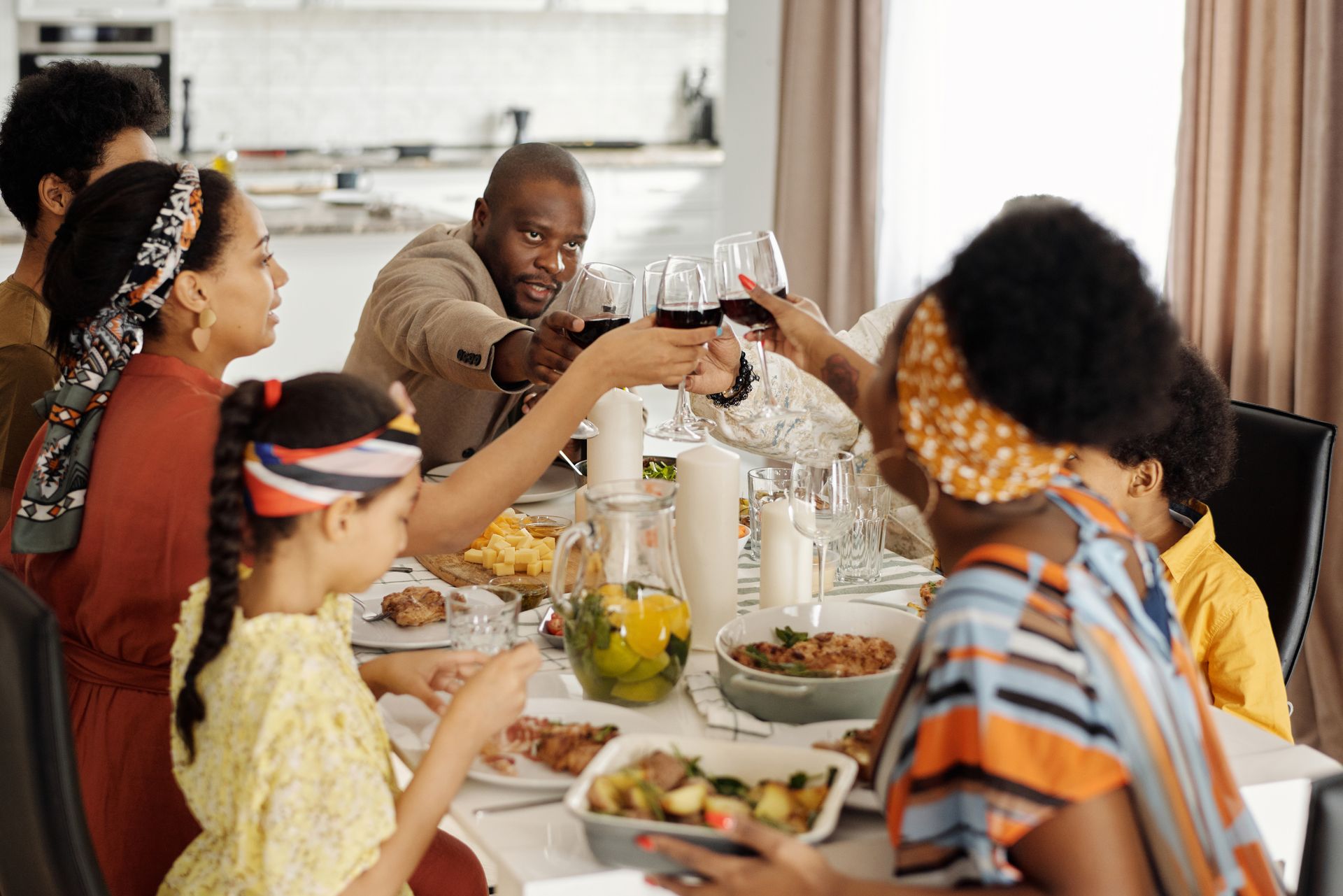 Three generations of a Black family sharing tea and conversation around a warm kitchen table