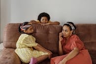 母亲和孩子坐在家里的沙发上，享受着室内的轻松家庭时光